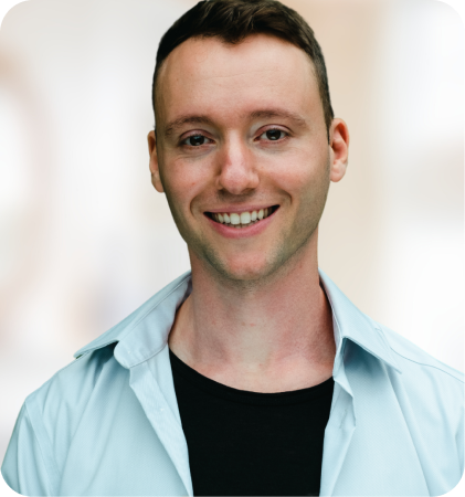 Portrait of a smiling man in a light blue shirt and black t-shirt